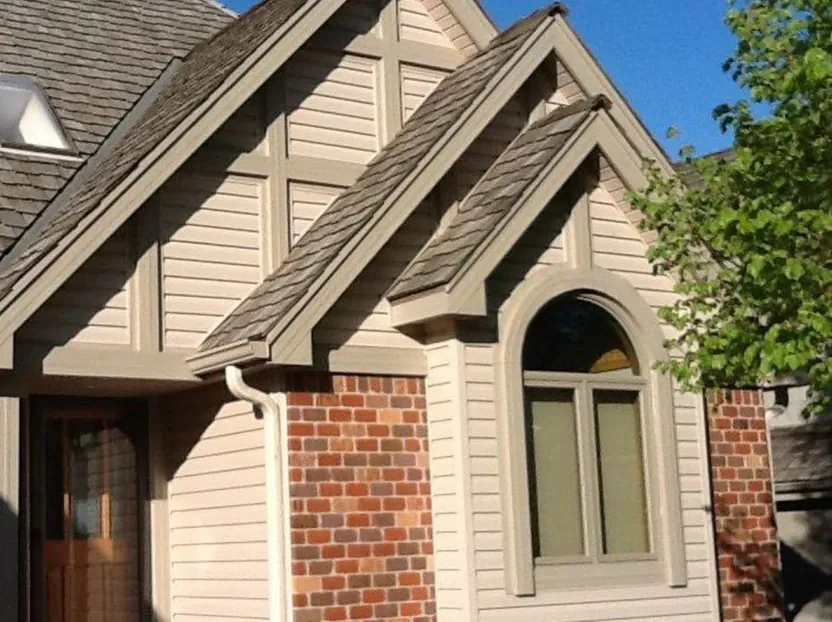 Two-story home re-sided in tan lap siding — after