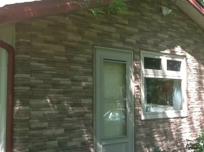 Entry wall re-clad in stone veneer siding — after