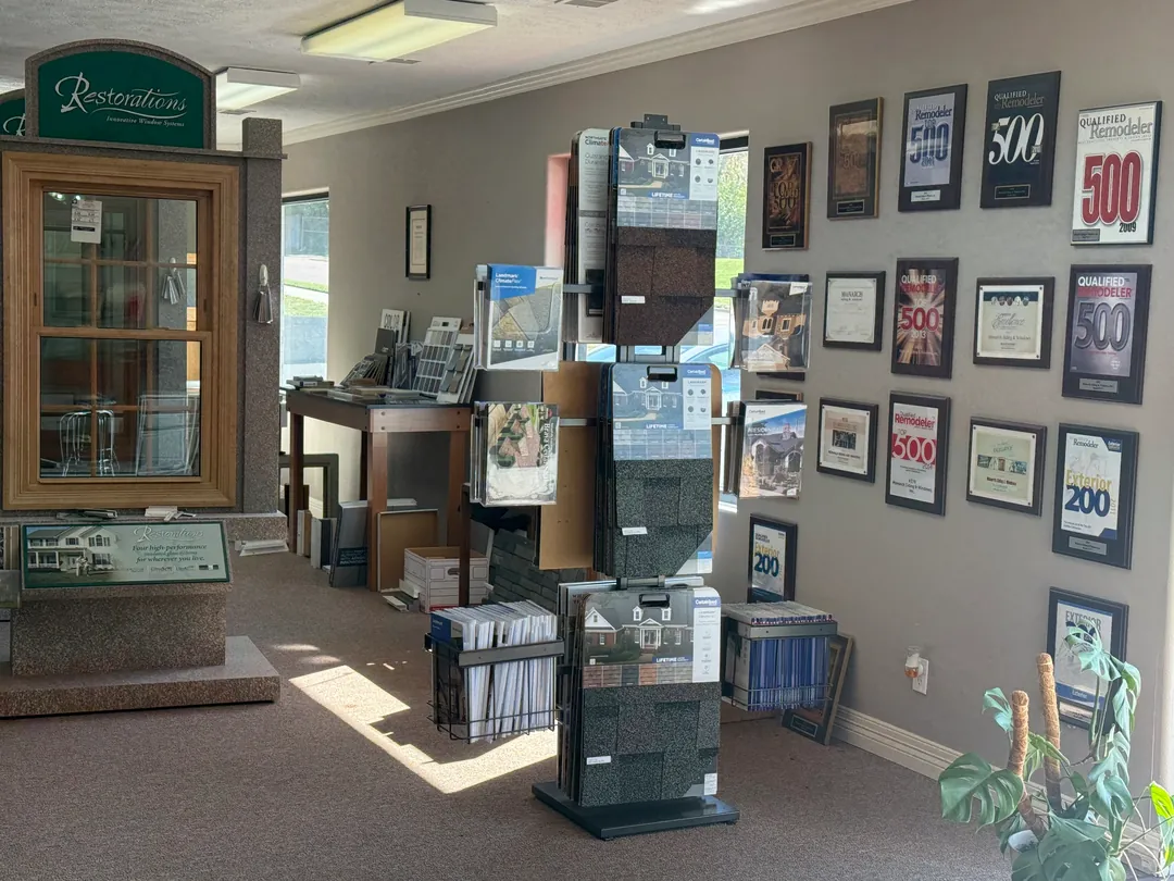 Qualified Remodeler Top 500 and Exterior 200 award plaques beside roofing samples in the Monarch showroom