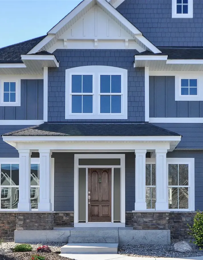 A blue fiber cement home with lap siding, shake gables and white trim